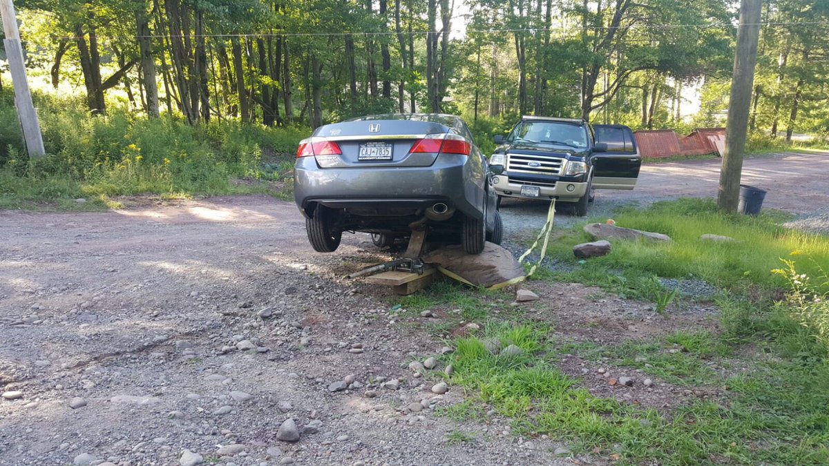 NYSChaveirim's tweet photo. How did Chaveirim get this car back on the road in the Catskills, they had to jack the car up and pull the rock out. https://t.co/APVTtT6rs5