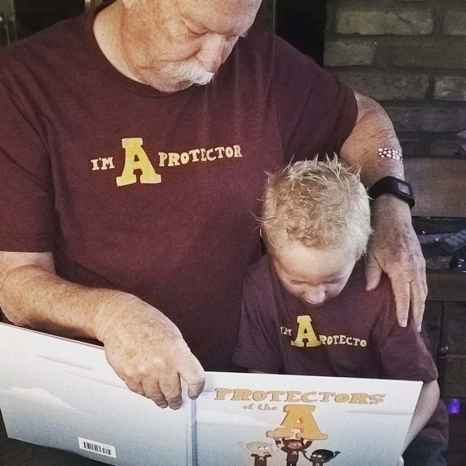 imaprotector's tweet photo. REPOST @kimake | Once "A" protector always an "A" protector! Easton &amp; Grampa enjoying a new book! #imaprotector https://t.co/x0fRx3e1tv