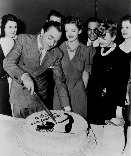 William Powell cuts his birthday cake with Myrna Loy, Virginia Grey &amp; other cast members on set of ANOTHER THIN MAN