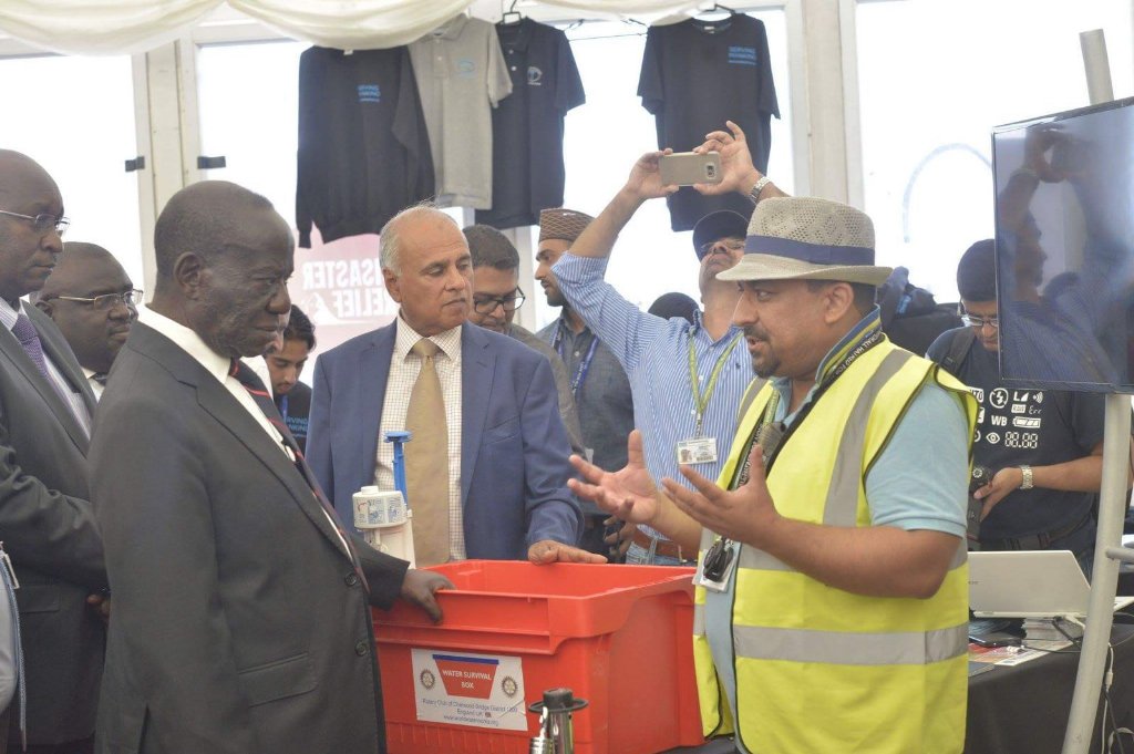 HumanityFirstUK's tweet photo. HF Disaster Response team showcase @watersurvival box to #Uganda Vice President at #JalsaUK https://t.co/T6OkqUA3b9