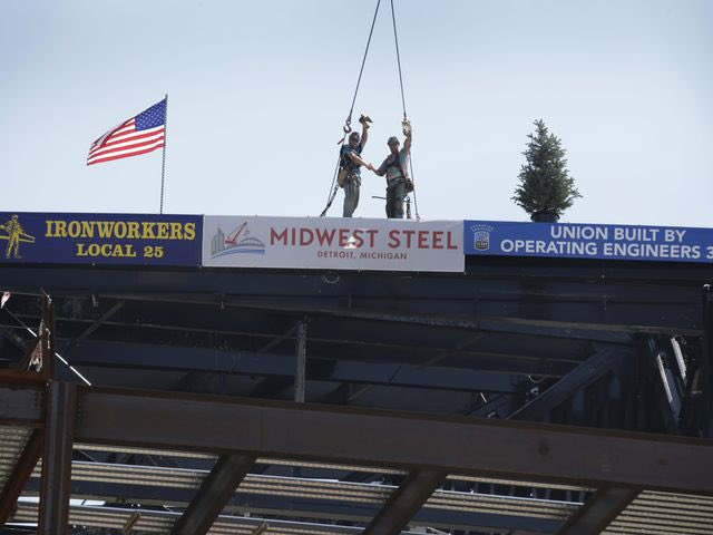 Workers raise the last beam on roof on Little Caesars hockey arena in Detroit  http://on.freep.com/2aTosBg 