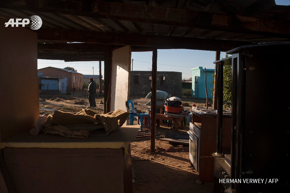 SAFRICA- A man stands next to a half demolished shack with belongings stacked outside, in Cullinan. By <a href="/hermanverwey/">Herman Verwey</a>