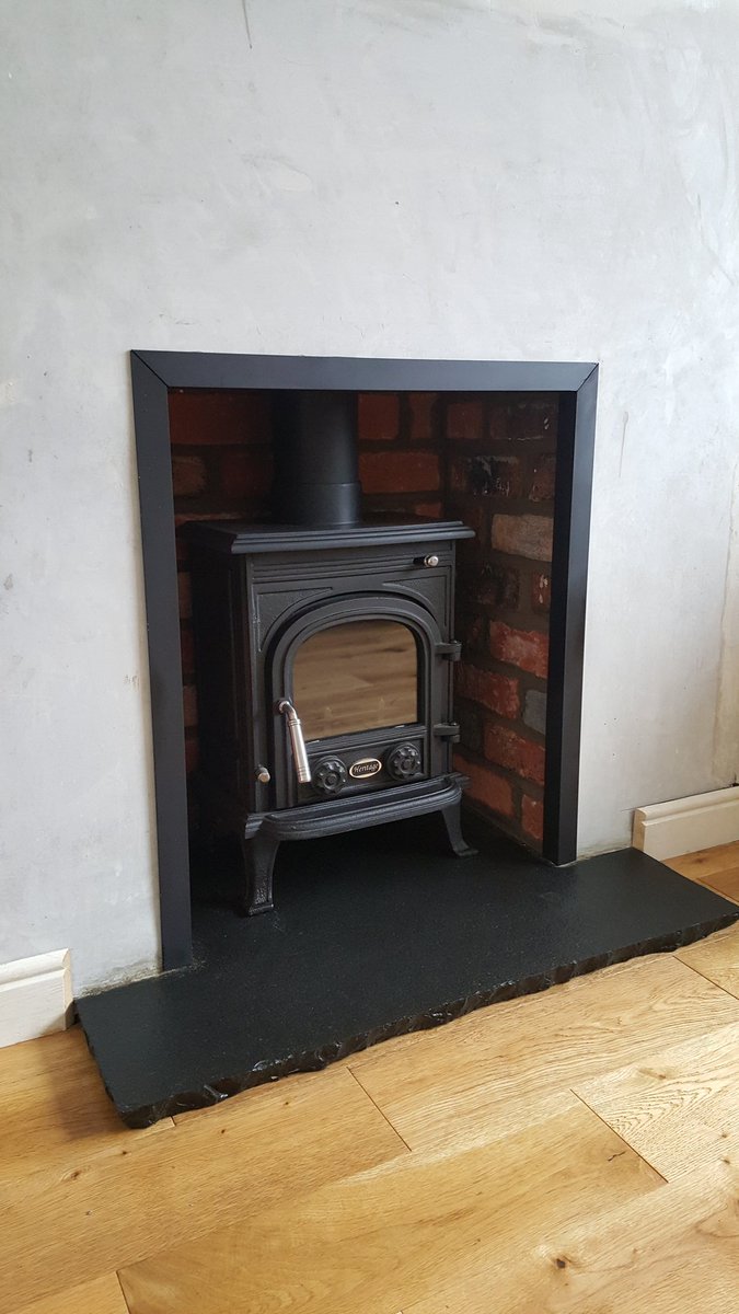 CleanflueNI's tweet photo. Firebox recess tiled with old #Belfastbrick  faces. Black Bezel custom made and fitted. Re-fitting of m/f #Stove https://t.co/Avqy8NzW4D