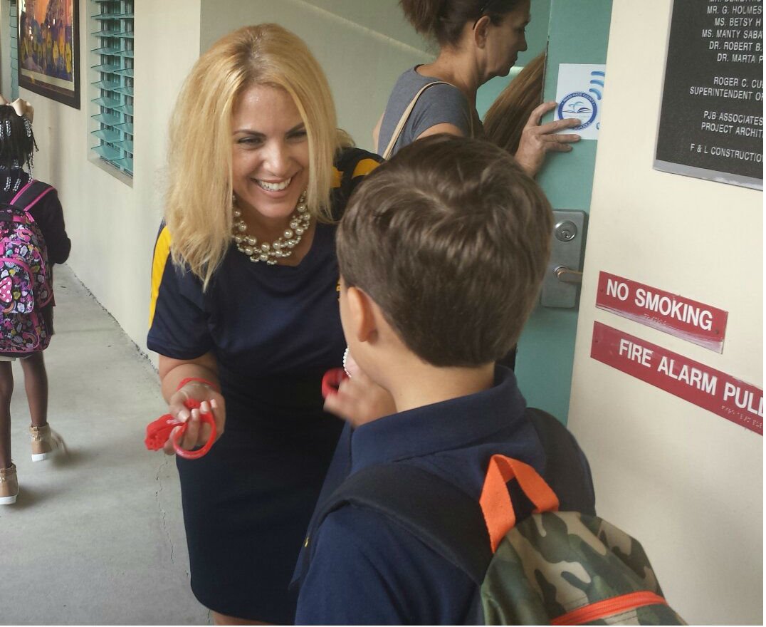 Principal Martinez-Lopez Welcoming Students Back to School with PAWS-itive bracelets for the 2016-2017 School Year!