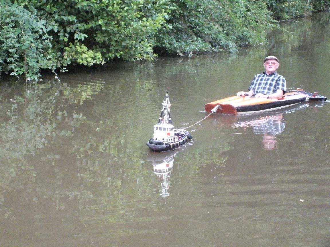 A Tiny Remote Controlled Tugboat Tows a Man in a Kayak Along a Canal in England laughingsquid.com/a-tiny-remote-…