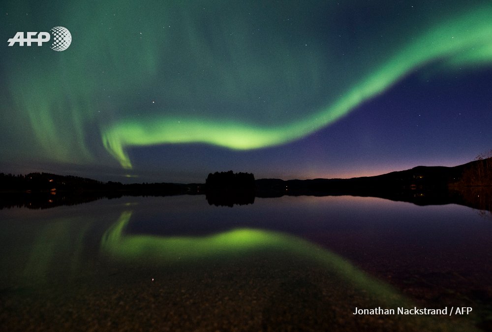 afpfr's tweet photo. #instantané Une aurore boréale illumine le ciel du village de Erikslund en Suède. Photos @jnackstrand #AFP https://t.co/MWy6uXpfwF