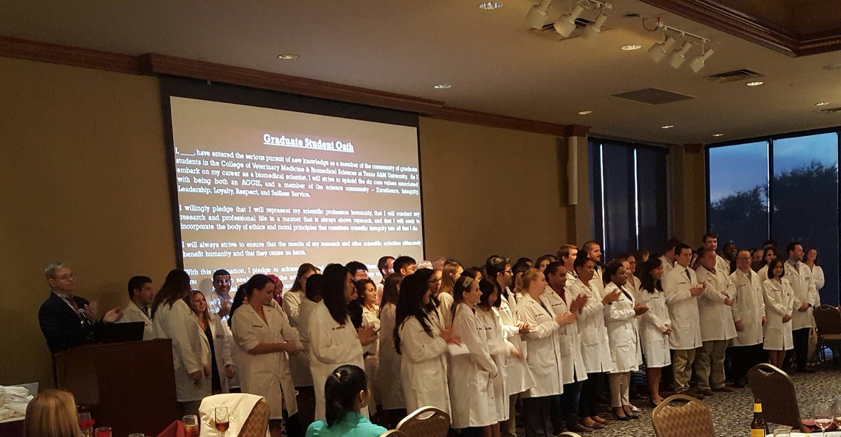 Grad students of <a href="/tamuvetmed/">Texas A&M VetMed</a> receive lab coats and recite a scientific oath at inaugural orientation oath ceremony