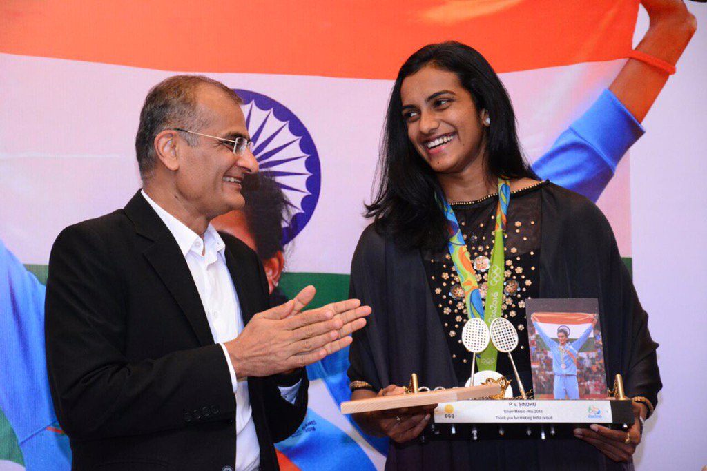 Edelweiss Chairman <a href="/rasheshshah/">Rashesh Shah</a> felicitates the lovely <a href="/Pvsindhu1/">Pvsindhu</a> as they share a private joke at <a href="/OGQ_India/">OGQ</a> event!