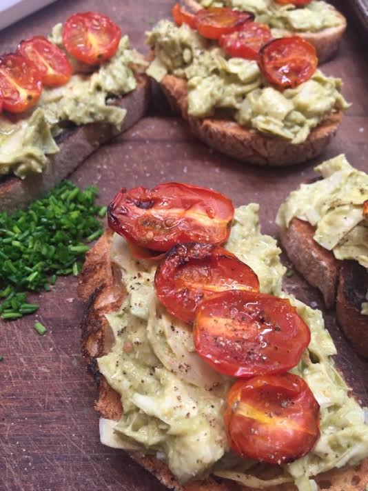 New open faced sandwich here for the eating: artichokes, fresh basil, hummus, topped with roasted summer tomatoes.