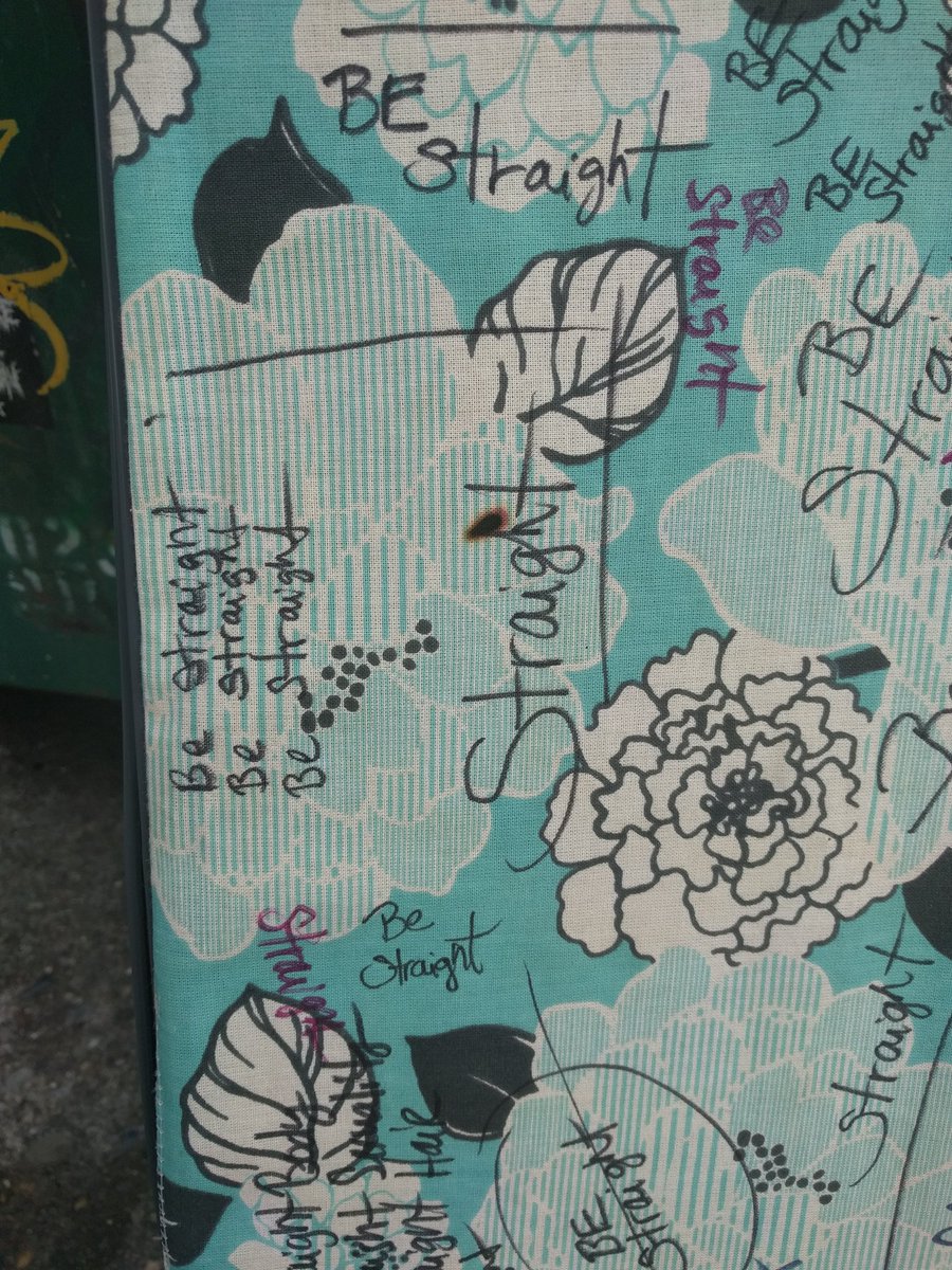 close-up of ironing board with sharpie marker writing "be straight" in many places