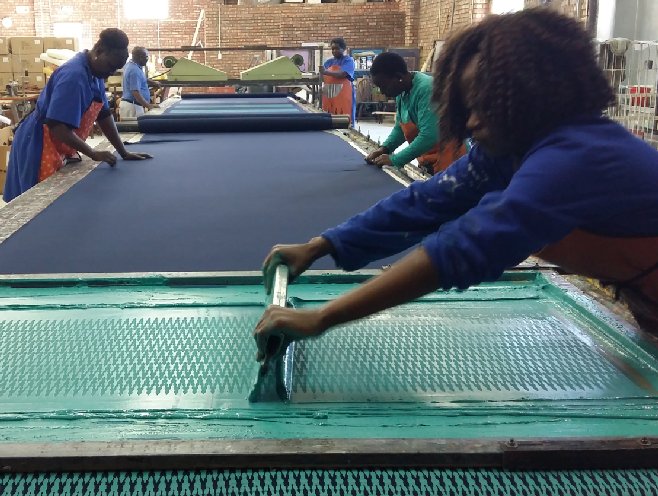 TsongaTextiles's tweet image. All hands on ... the printing table @ Tsonga Textiles. #screenprinting #tsongatextiles #fabric