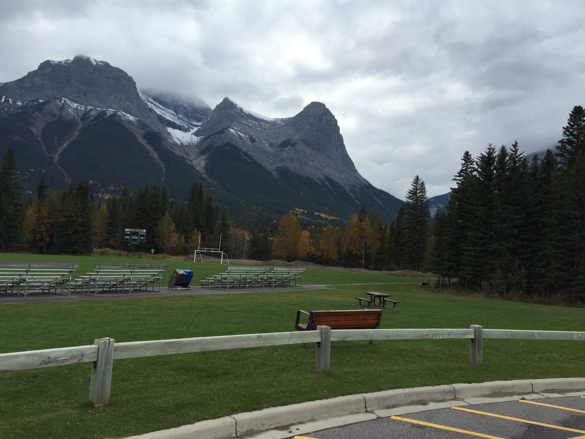 EnjoyCanmore's tweet photo. Love the contrast with the green grass and clouds with a fresh dusting of snow #Canmore https://t.co/3bjGFXmWyW