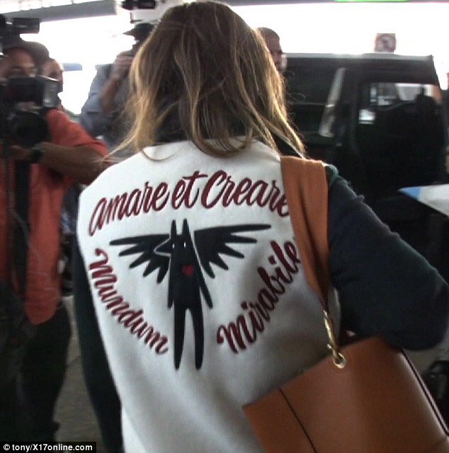 Emilia_Updates's tweet photo. Emilia Clarke was wearing this jacket that says "To love to create a wonderful world" https://t.co/aFQ5qd20k7