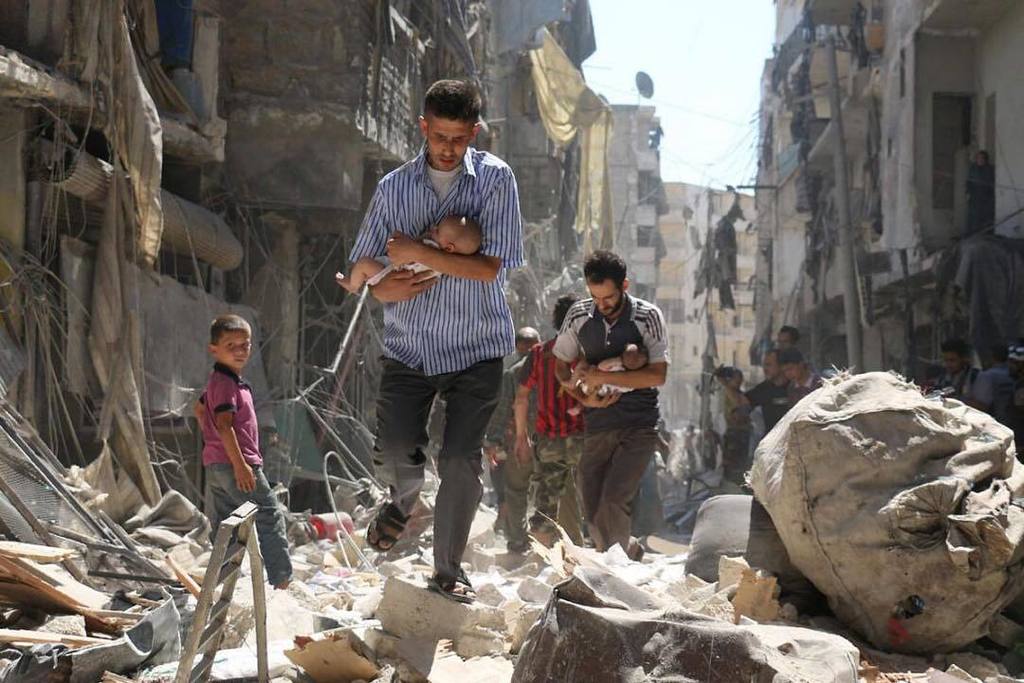 TorontoStar's tweet photo. From the #PhotoDesk: Amidst the rubble — Syrian men carrying babies make their way through… https://t.co/fCKgp0tp4f https://t.co/ZDfjBNAZfX