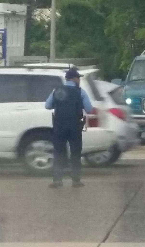 AlexDelgadoPR's tweet photo. Este agente está desde las 8 am en el semáforo de la #1 esquina antiguo Logans. A las 4:30 sigue allí. Mis respetos. https://t.co/13KgqlYUKX
