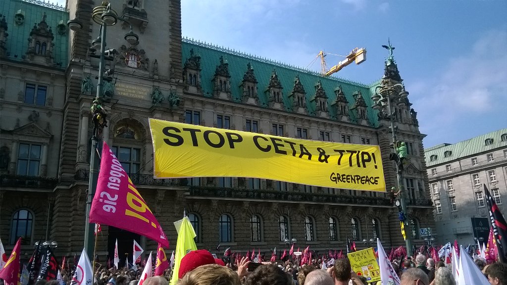 Greenpeace-Aktivistinnen und Aktivisten hängen zwei große Banner am Rathausmarkt #StopCetaTTIP in #Hamburg