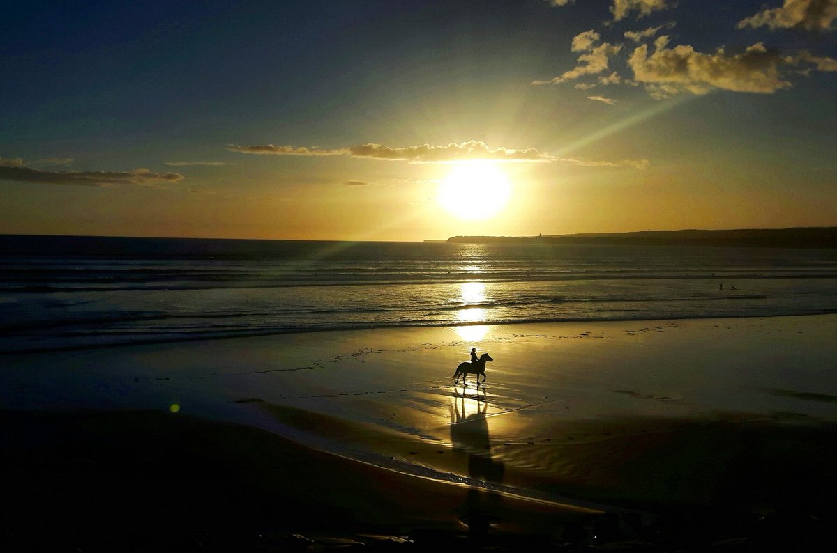 A lone horse-rider stands against a perfect Lahinch sunset...