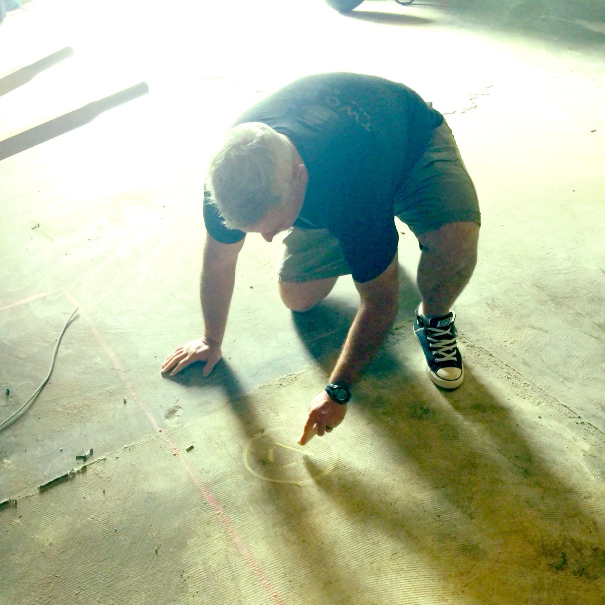 RustyBullBeer's tweet photo. We're not sure if Brian is planning where a drain will go or playing hangman... #buildingthebrewery #RustyBull #NorthCHSbeer https://t.co/yzOBuS787E
