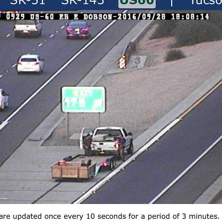 Man in the wooden box at US 60 and Alma School now joined by a truck with a flatbed. The mystery continues! fox10p…