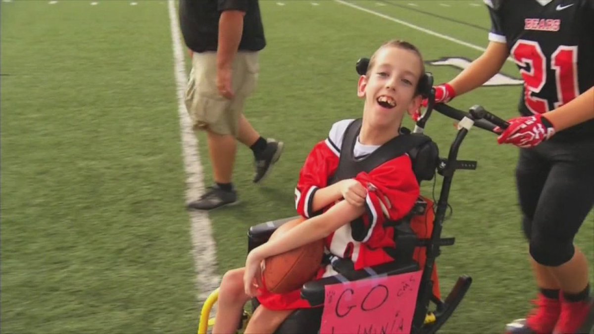 Rival teams help boy with cerebral palsy score touchdown in honor of late father