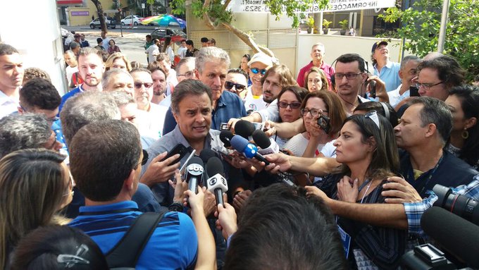 Foto do senador Aécio Neves, ao lado de João Leite, dando entrevista para a imprensa no seu local de votação em Belo Horizonte (MG).