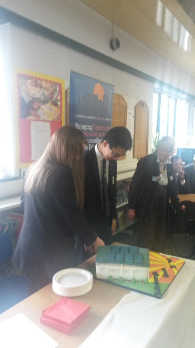 CoopsWork's tweet photo. Head Girl and Head Boy of Currie High cut @EdinSolarCoop cake to mark completion of project. @Energy4AllLtd @Edinburgh_CC #communityenergy https://t.co/dVCLHPyc6B