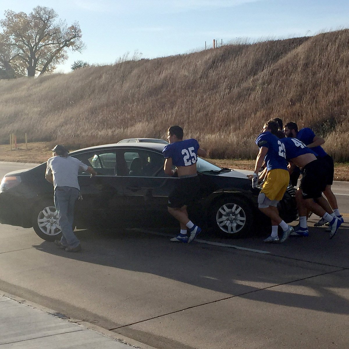 GottulaTodd's tweet photo. Car stalls on street near stadium - @UNK_Football @UNK_Athletics guys jump into action and help #LoperStandard #LoperFamily #Community https://t.co/2dJEGkb5QT