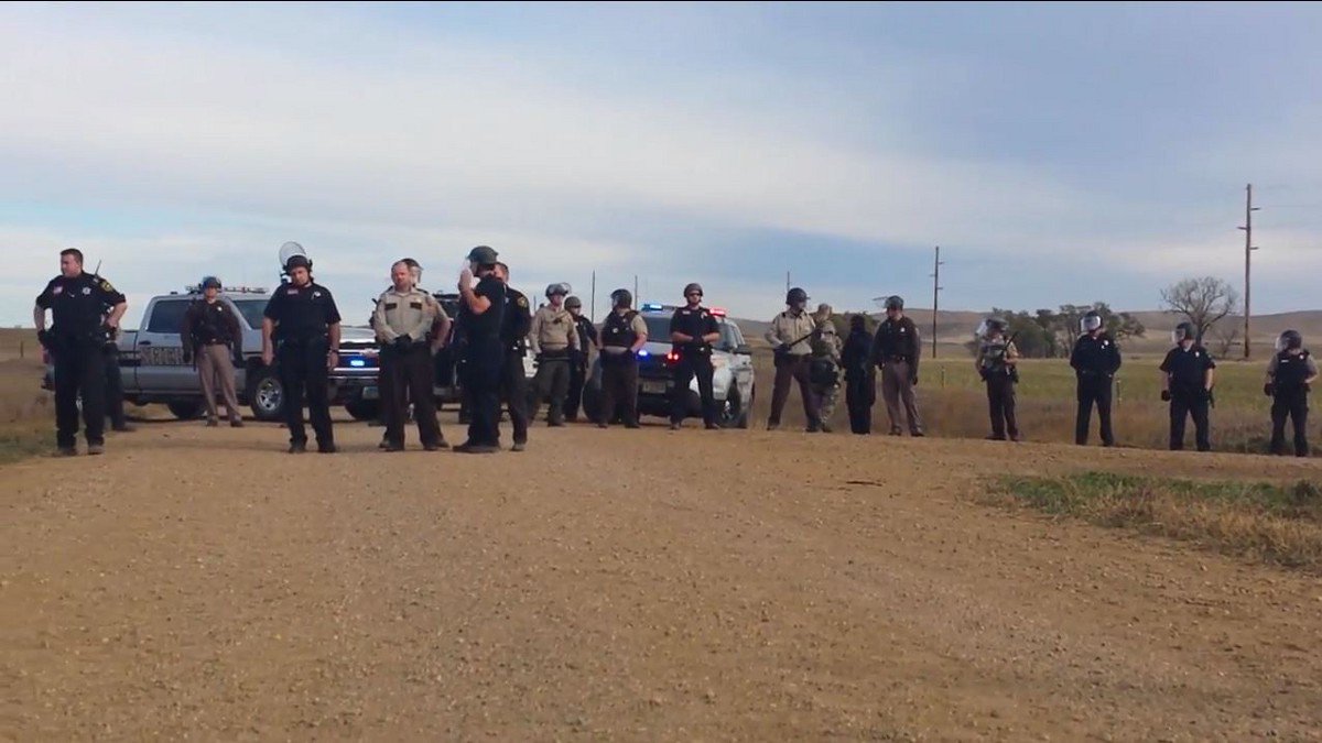 thinkprogress's tweet photo. Armed police swarm Native Americans praying along North Dakota road https://t.co/yKdC97Hq5N https://t.co/Q7KWhohwAY