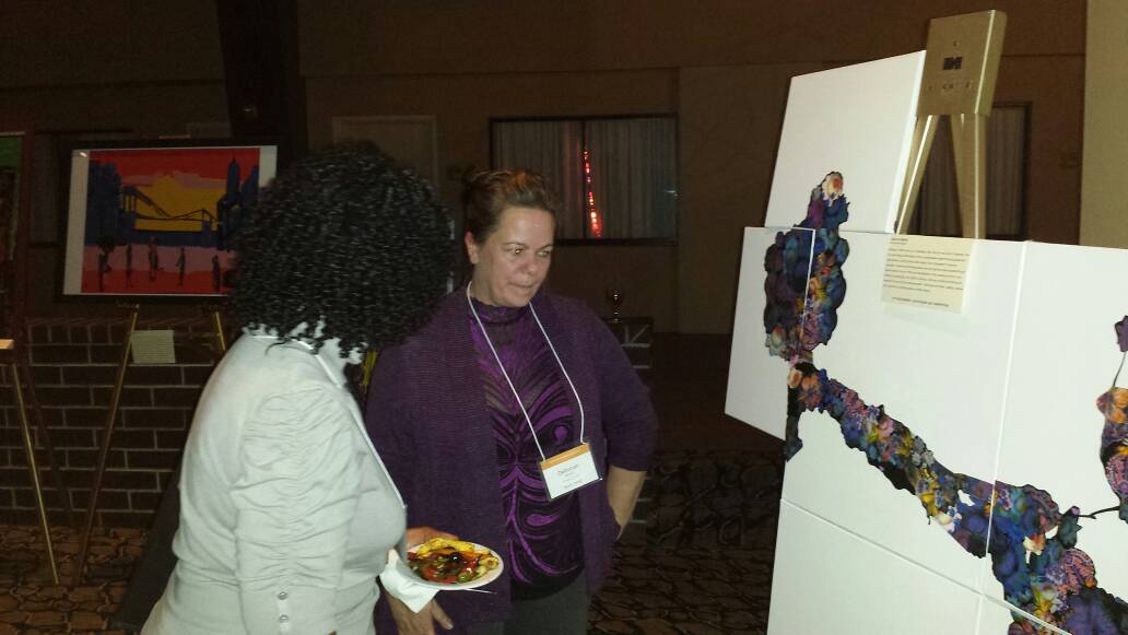SUNYEmpire's tweet photo. Student-artist Deborah Berlin talks with another student about her award-winning work. #StAC2016 https://t.co/N8bMC69Fd8