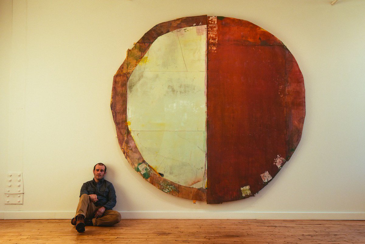 artist Daniel John Gadd seated next to his monumental painting, "I Know Rivers" (2016, 120” x 115”), in his just-opened solo exhibition.