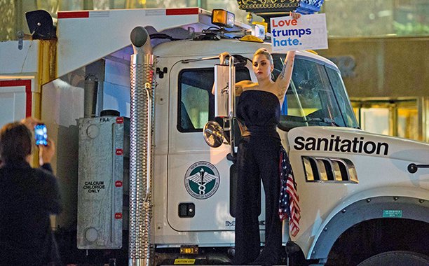 EW's tweet image. Lady Gaga protested outside Trump Tower following Clinton's loss, holding a sign that read “Love trumps hate”: share.ew.com/4AMhsbJ