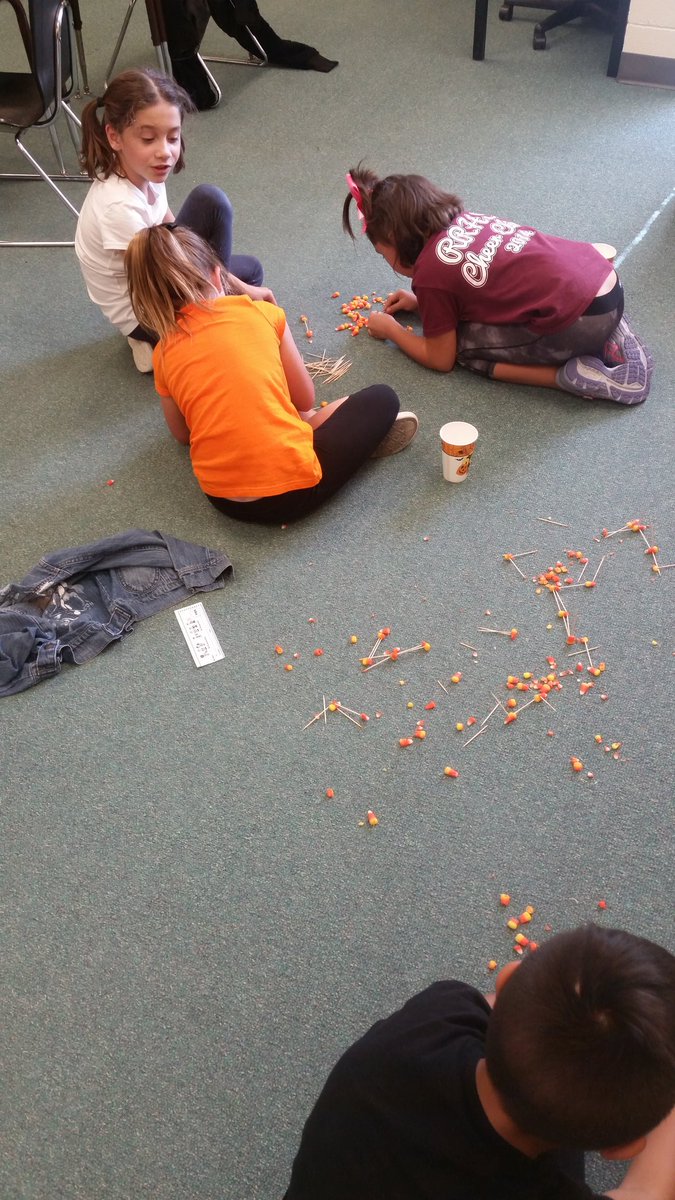 Attempting to build a sturdy structure using candy corn and toothpicks.