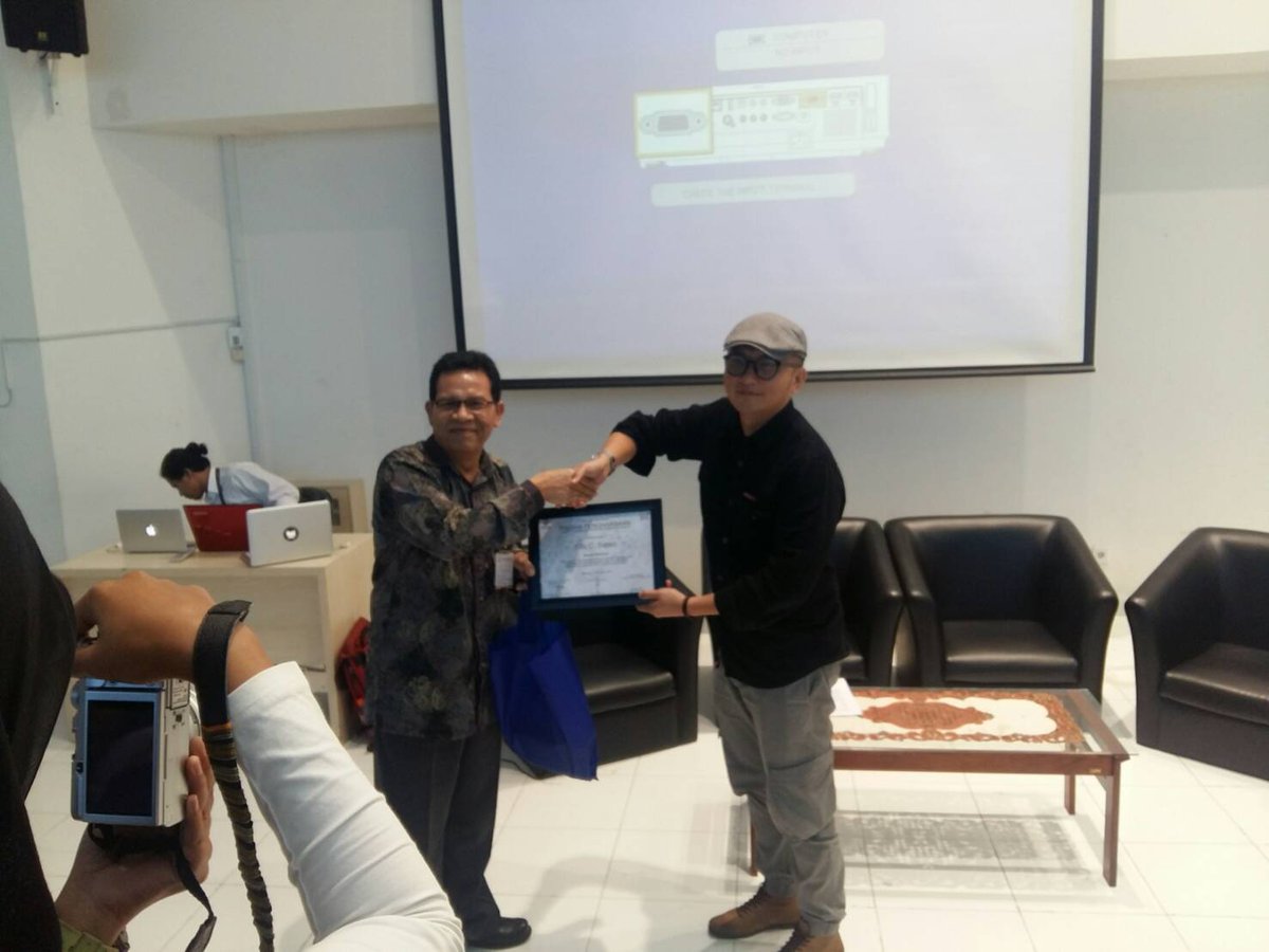 Penyerahan plakat dari Dekan Fakultas Komunikasi Bisnis, kepada kang Fiki Satari