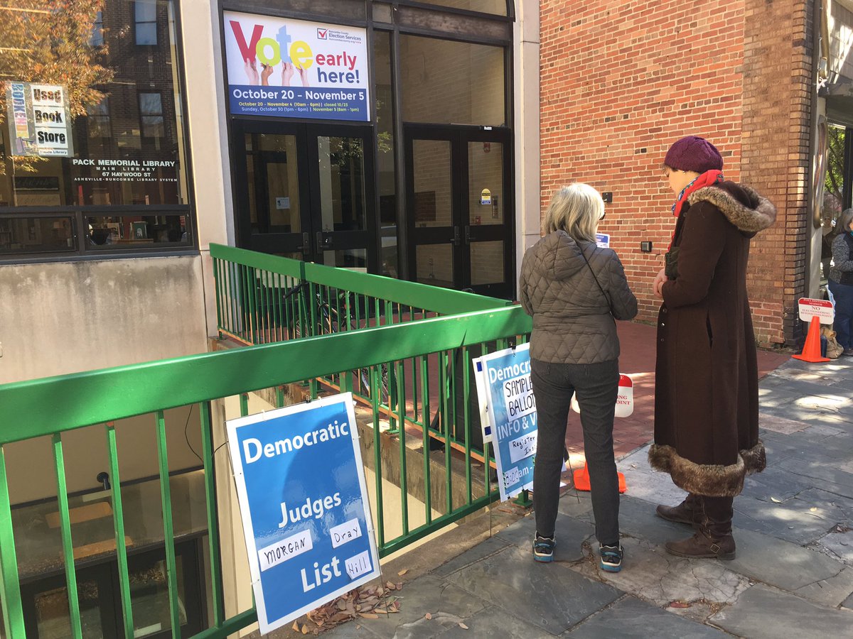 mtracey's tweet image. Democratic Party volunteers outside early voting site in Asheville, NC telling people that the FBI email investigation is a GOP conspiracy