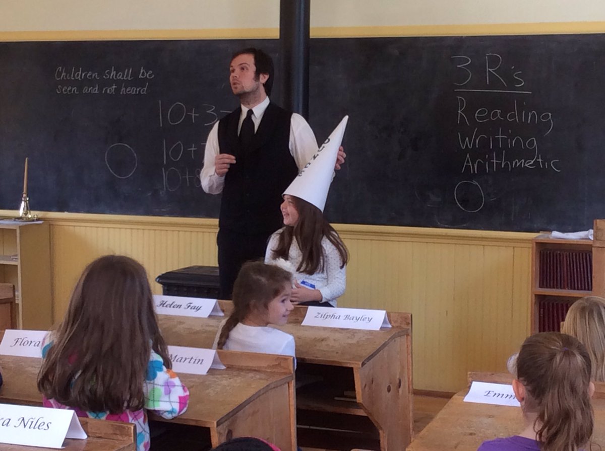 Learning about the rules of an 1800‘s one room schoolhouse at Poppleton School. #fraserfamily #teamtwain