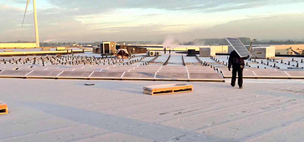 PureEnergieNL's tweet photo. Stoere kerels van @PureEnergieNL al heel vroeg aan het werk, 400 zonnepanelen op dak @Doeleman_Log direct naast windmolen #Waddinxveen #A12 https://t.co/8JP7y4PXCs