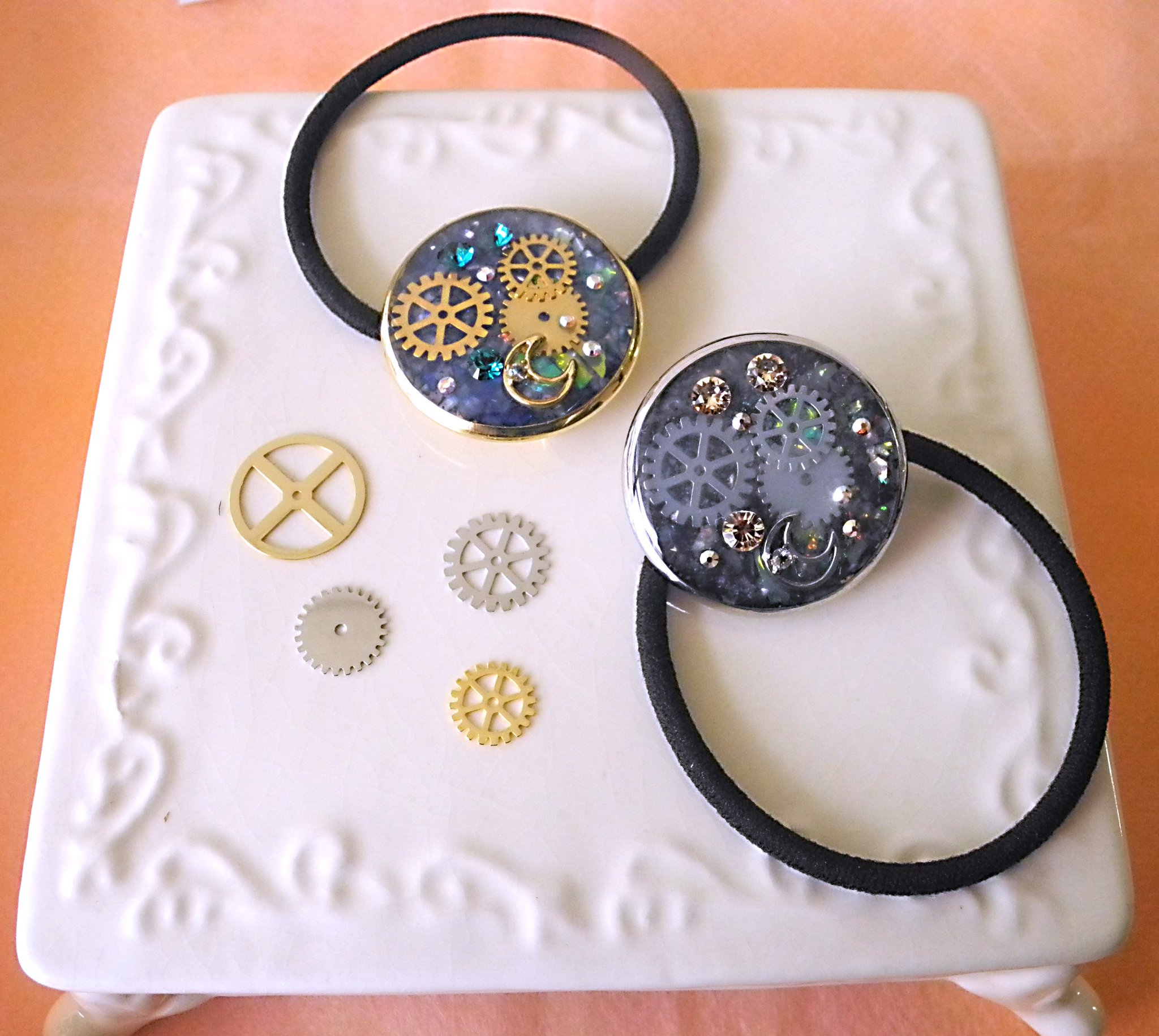 パーツクラブ プラネット バンド 数種類の歯車パーツを閉じ込めたuvレジンのヘアゴム こちらの作り方は パーツクラブの新しいレジン本 Uvレジンのabc に記載されております 11月下旬 12月初旬より販売開始予定です ぜひチェックしてみて