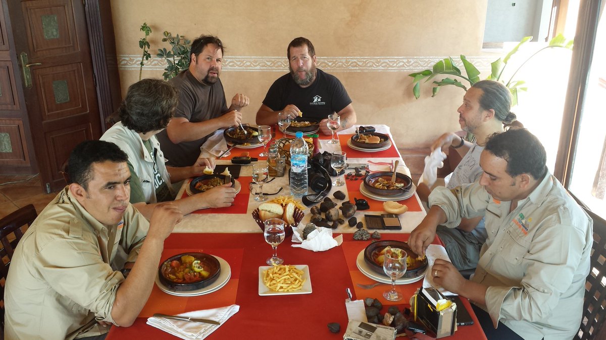 Woodtoast's tweet photo. A motley crew at a table full of assorted tagine dishes and a diverse collection of #meteorites I must be in heaven! #NWA2016 https://t.co/MMBxrplrMU