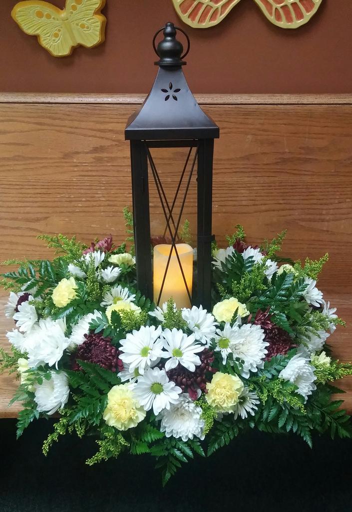 Tribute arrangement..lantern with candle and fresh floral.