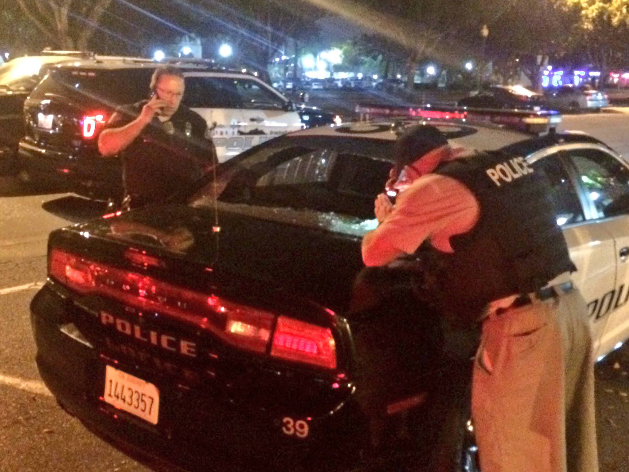 Photo Officers examining police car shot in Baldwin Park, Calif