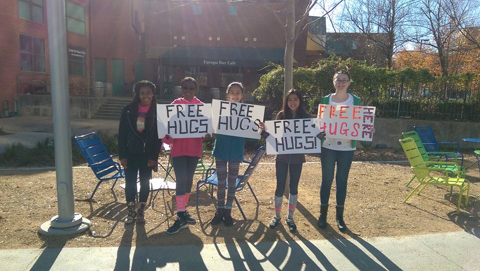 GCSchoolsNC's tweet photo. Students from Southeast High were downtown this Saturday during the Greensboro Holiday Parade spreading community cheer, one hug at a time. https://t.co/WryU5SD9uf