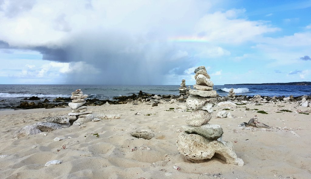 CarolynCSB's tweet photo. Beach art, rain, a little rainbow and the ocean. Perfect place to watch nature do its thing @SandyIslandAXA @anguillabeaches @Anguilla_Trsm https://t.co/2DUTVfpRZh