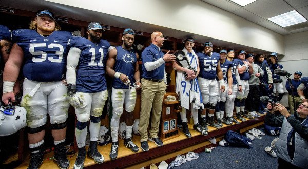 PennStateFball's tweet photo. Senior @evan_schwan won the accessories game post-#MSUbeat. @NittanyvillePSU banner around his neck & #B1G East trophy in hand. #WeAre https://t.co/BWuBHdRqAK