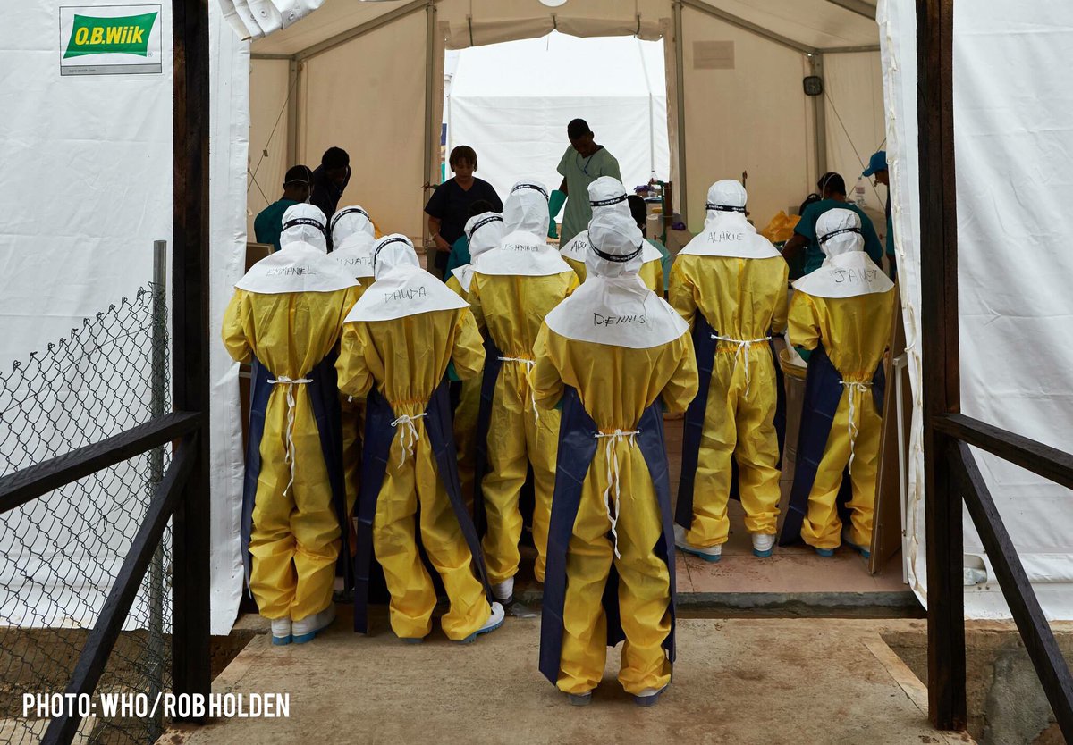Emergency medical team in their personal protective equipment gather for a briefing during Ebola outbreak in West Africa