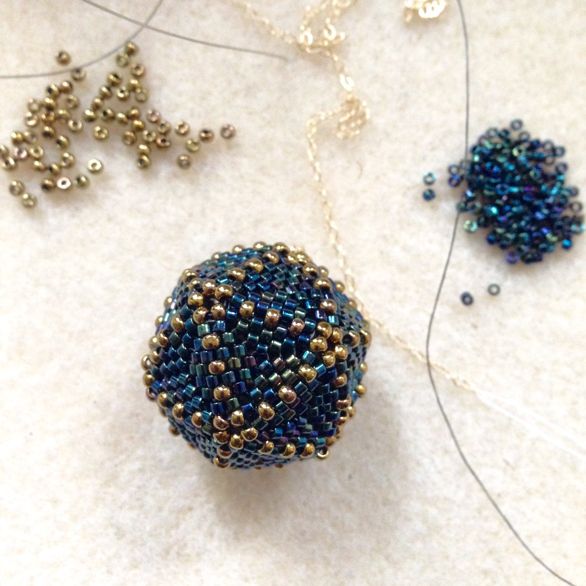 SunDropsStudio's tweet photo. Almost finished new #icosahedron pendant necklace for a custom order. #platonicsolids #iheartgeometry #beadstitching #mathart #supportlocal https://t.co/01zlsYDbQC