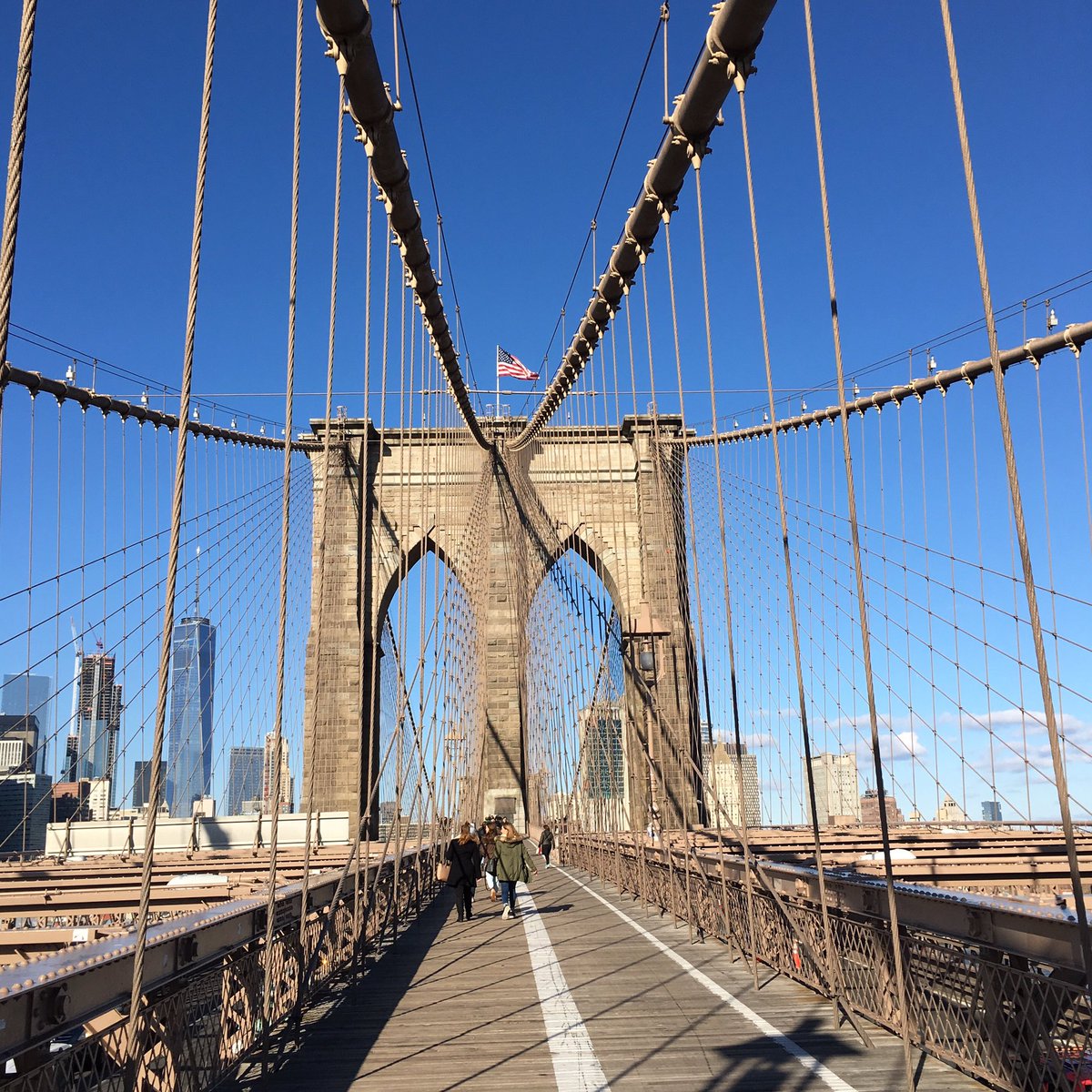 I love Brooklyn Bridge. The flag, the worn planks, the cables, the blue, blue sky. Overjoyed for a break in the wet weather.