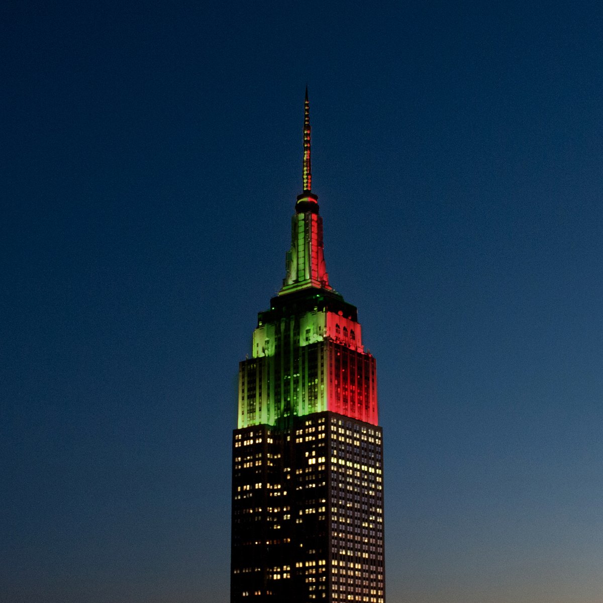 EmpireStateBldg's tweet photo. The Empire State Building is honoring the final #MLSCup teams with split lights tonight: green for @SoundersFC &amp; red for @TorontoFC. https://t.co/FEHOghXC8v