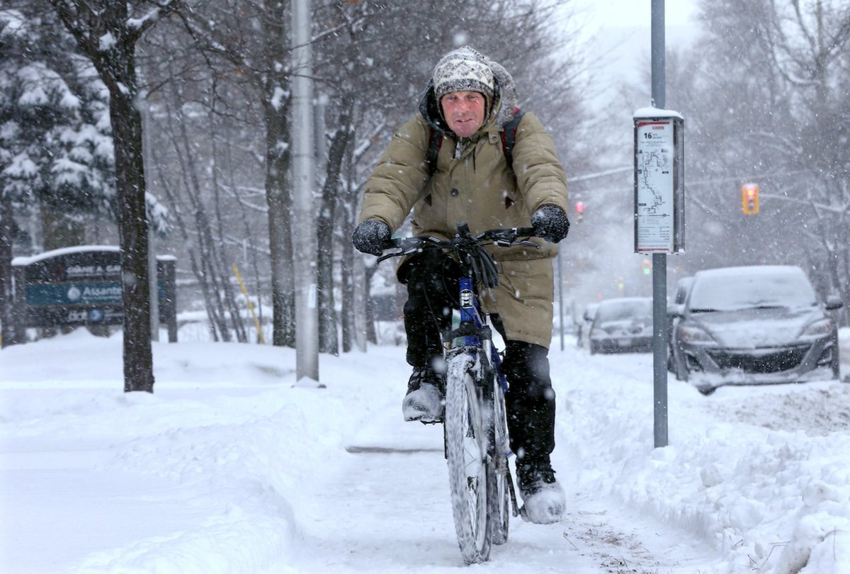OttawaCitizen's tweet image. Oh, Canada. More than 15 cm of snow from this storm, but our photographers still found cyclists out this morning. This is from Sandy Hill: