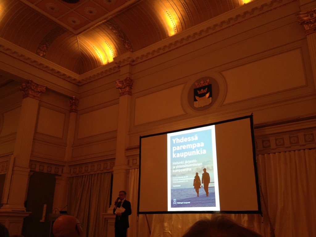 Kaupungintalon juhlasalissa: Helsinki järjestö- ja yhteisötoiminnan kumppanina. Hienot kristallikruunut täällä.