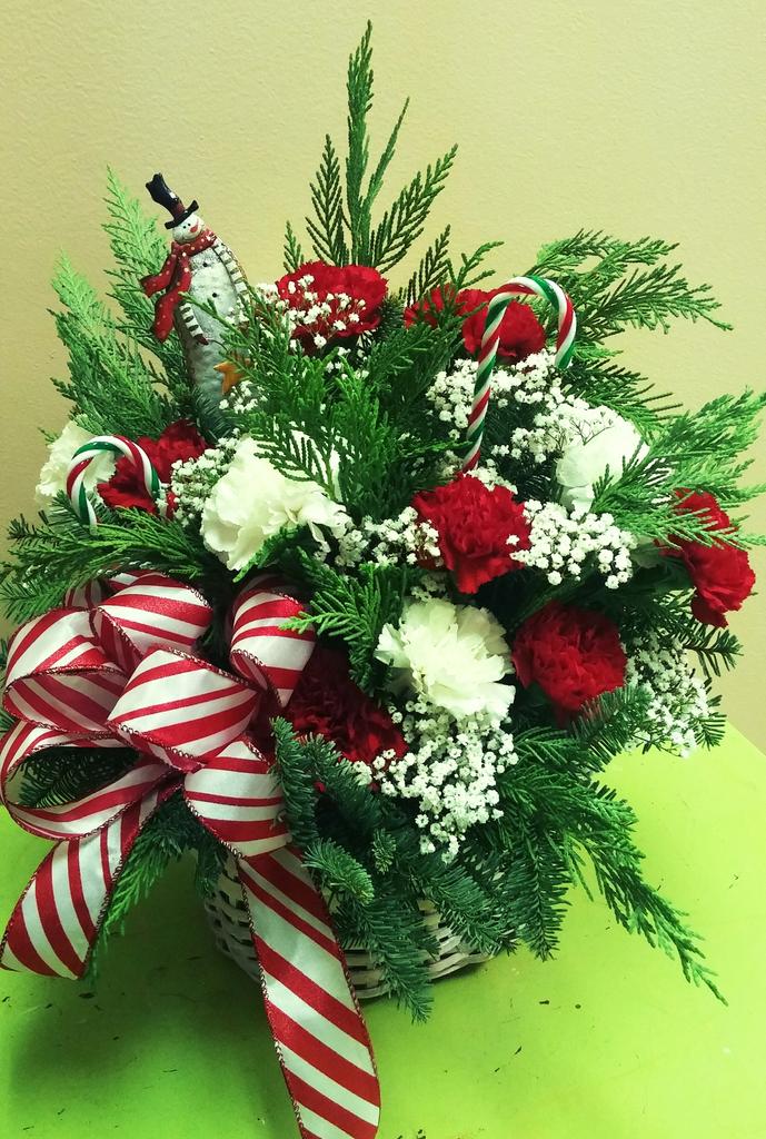 Snowman and candy canes in white basket full of flowers, holiday greens and Christmas cheer!!! 🎅